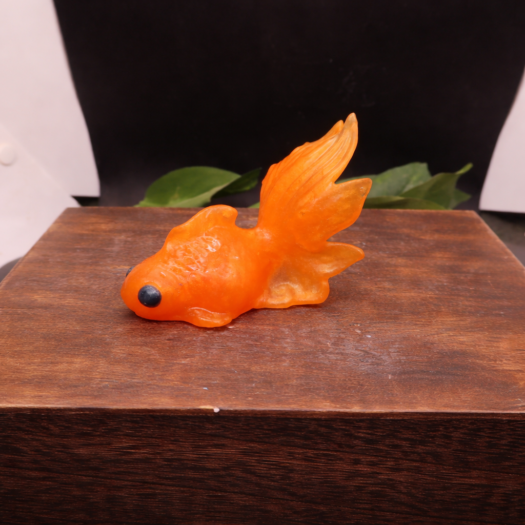 Close-up of orange fish-shaped glycerin soap bar highlighting texture, transparency, and hand-crafted detail.