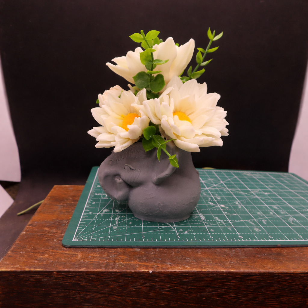 Daisy garden in elephant pot on cutting mat for size reference