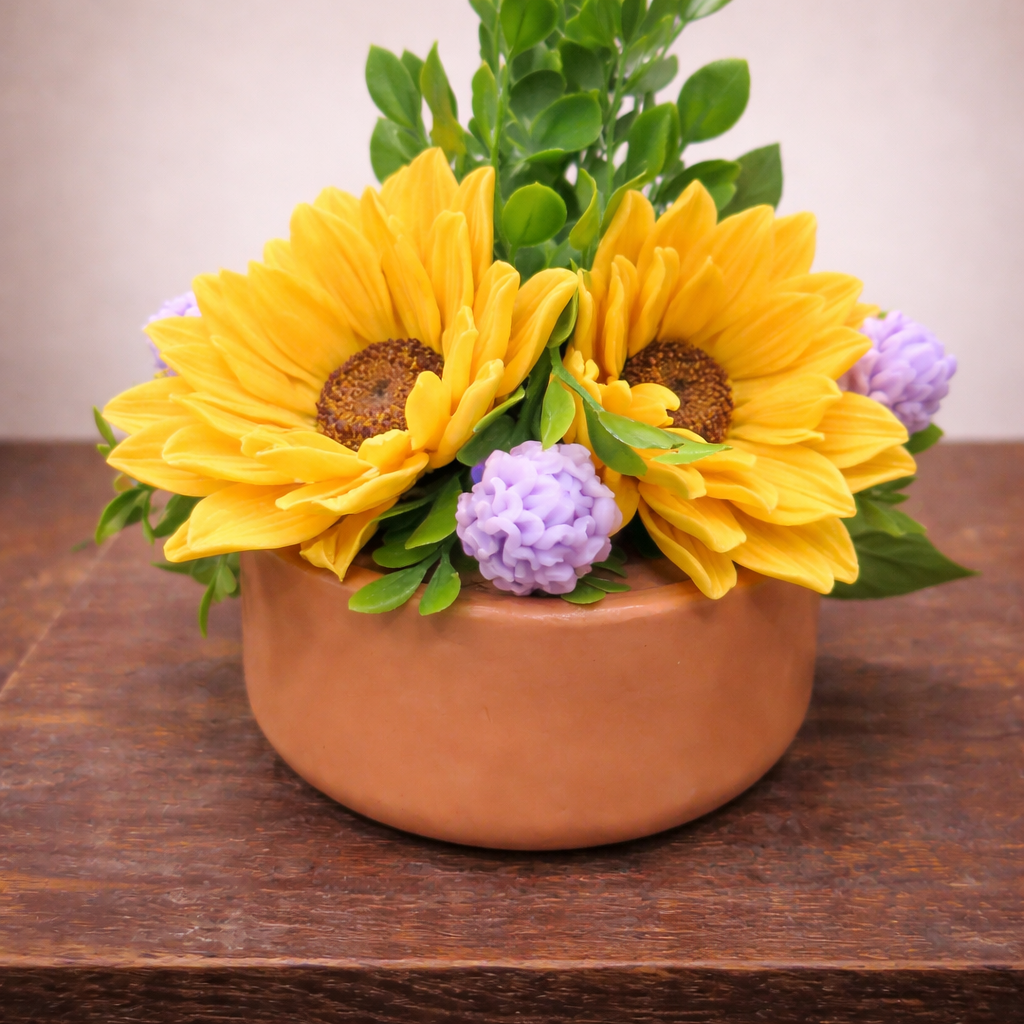 Handmade sunflower goat milk soap arrangement with four yellow sunflower soaps, clover flower soaps, ladybug detail and decorative soap pot.