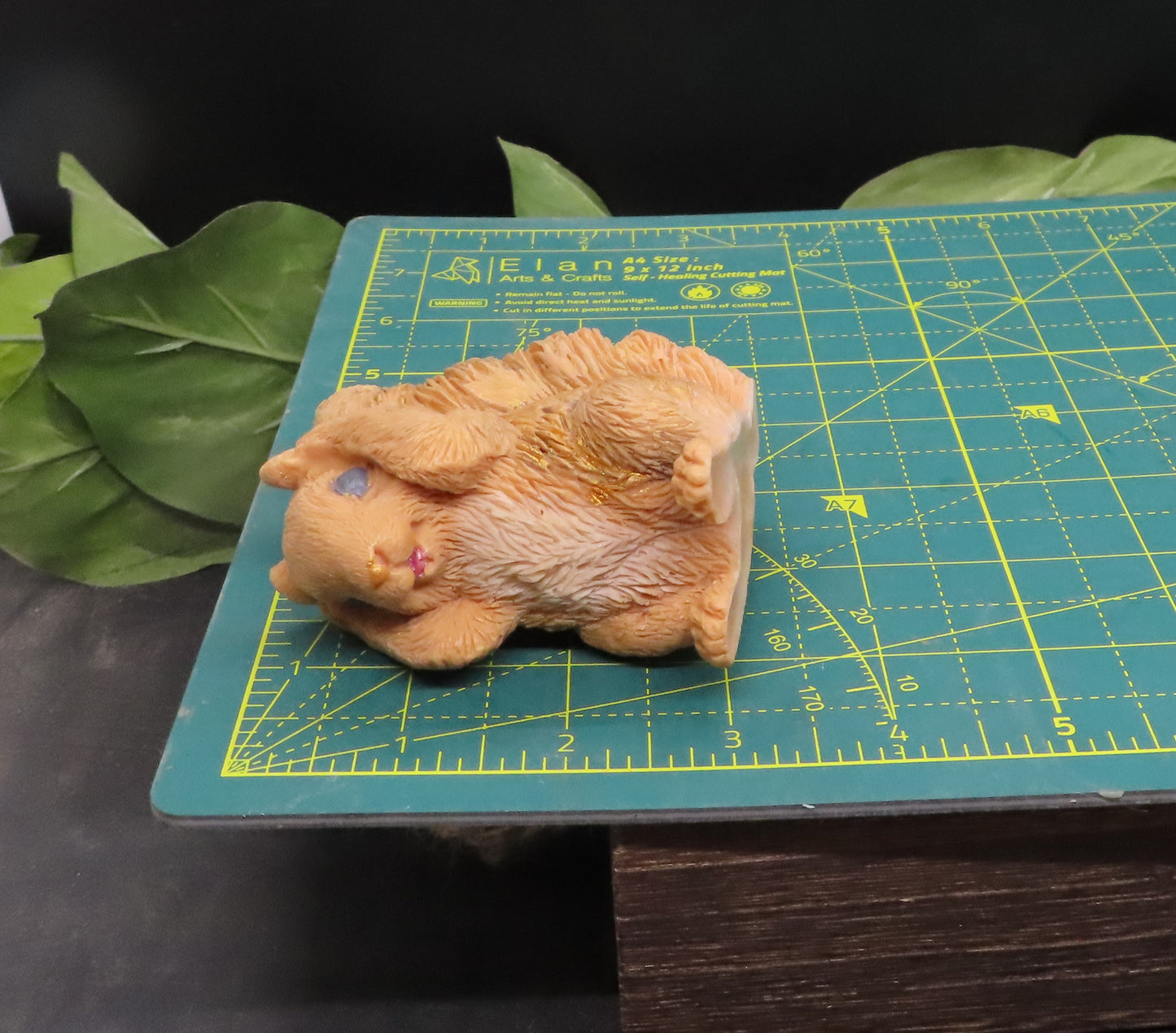 Hear no evil red squirrel goat milk soap displayed on a cutting mat to show approximate size and scale for reference.