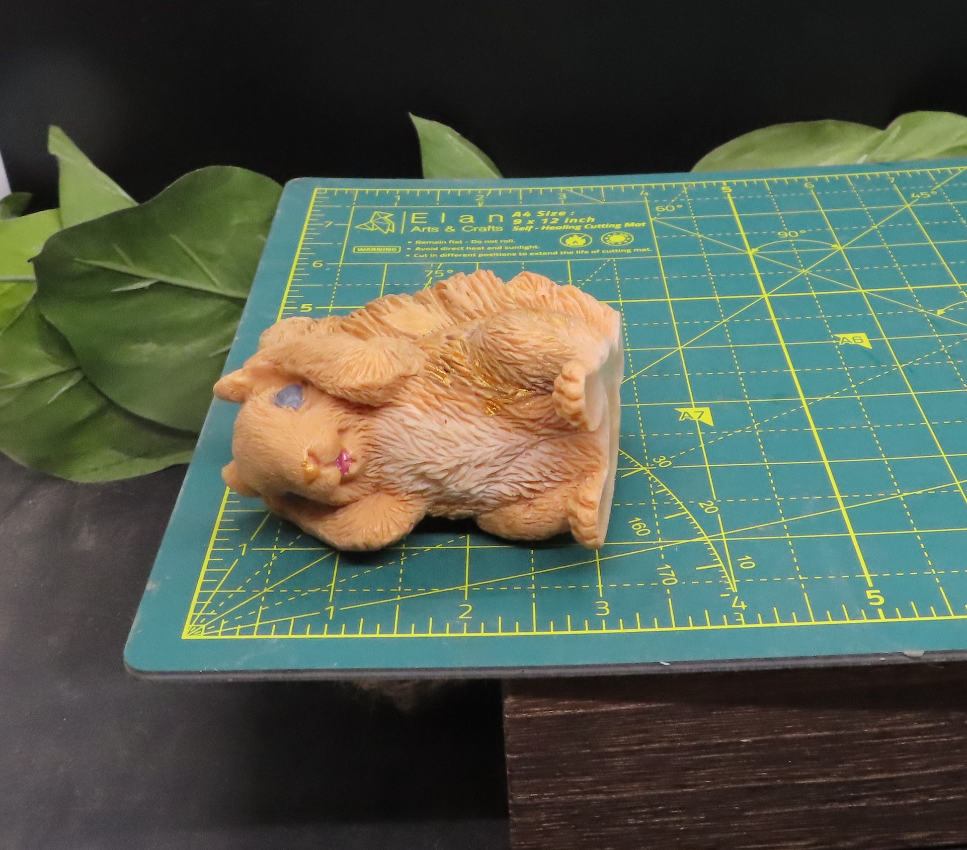 Hear no evil red squirrel goat milk soap displayed on a cutting mat to show approximate size and scale for reference.