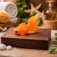 Orange goldfish glycerin soap bar, individually handcrafted fish-shaped novelty soap styled as bathroom décor on a rustic wood platform.