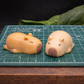 Sleepy capybara soap bars on cutting mat for size reference