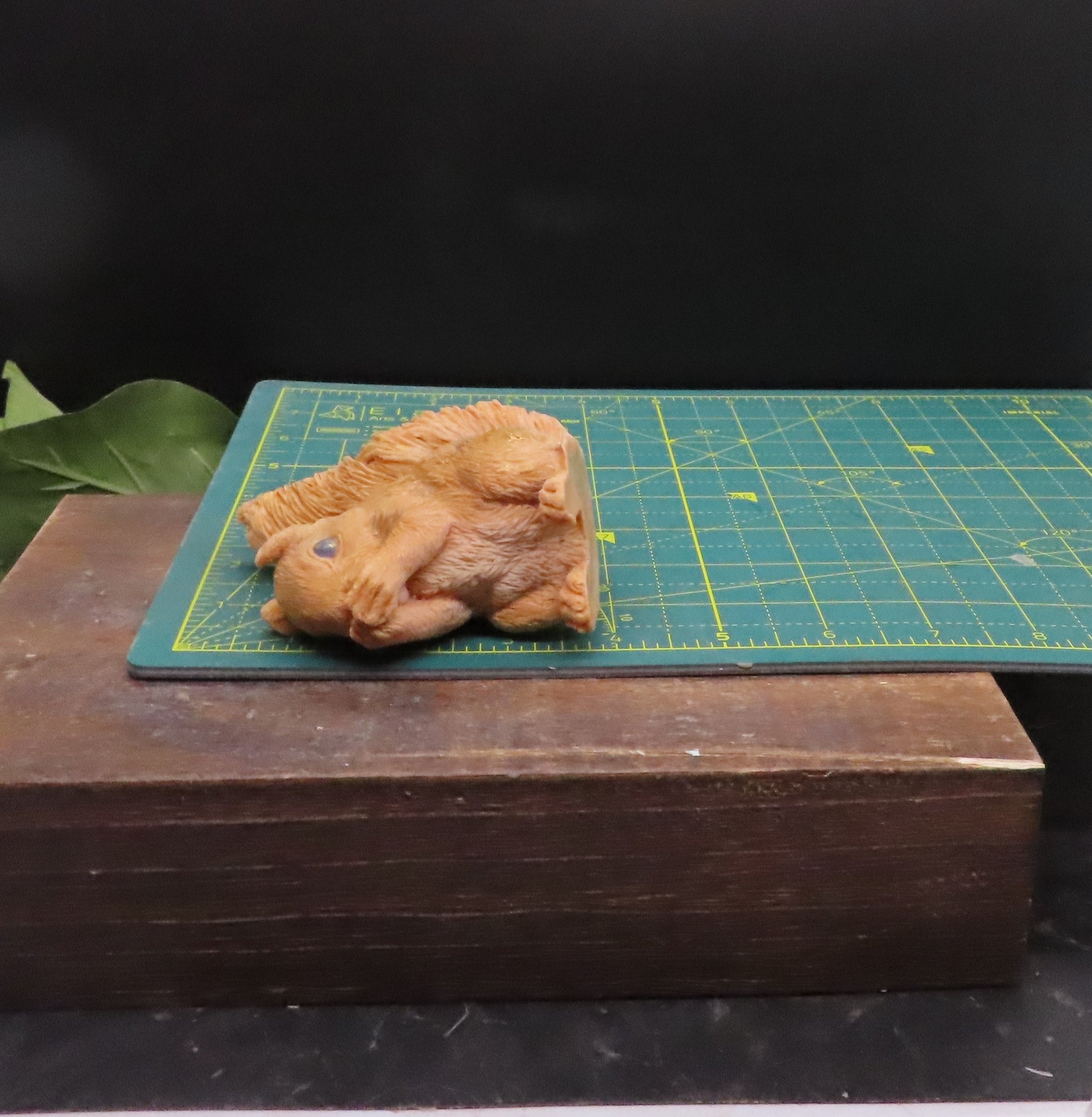 Speak no evil red squirrel goat milk soap displayed on a cutting mat to show approximate size and scale for reference.