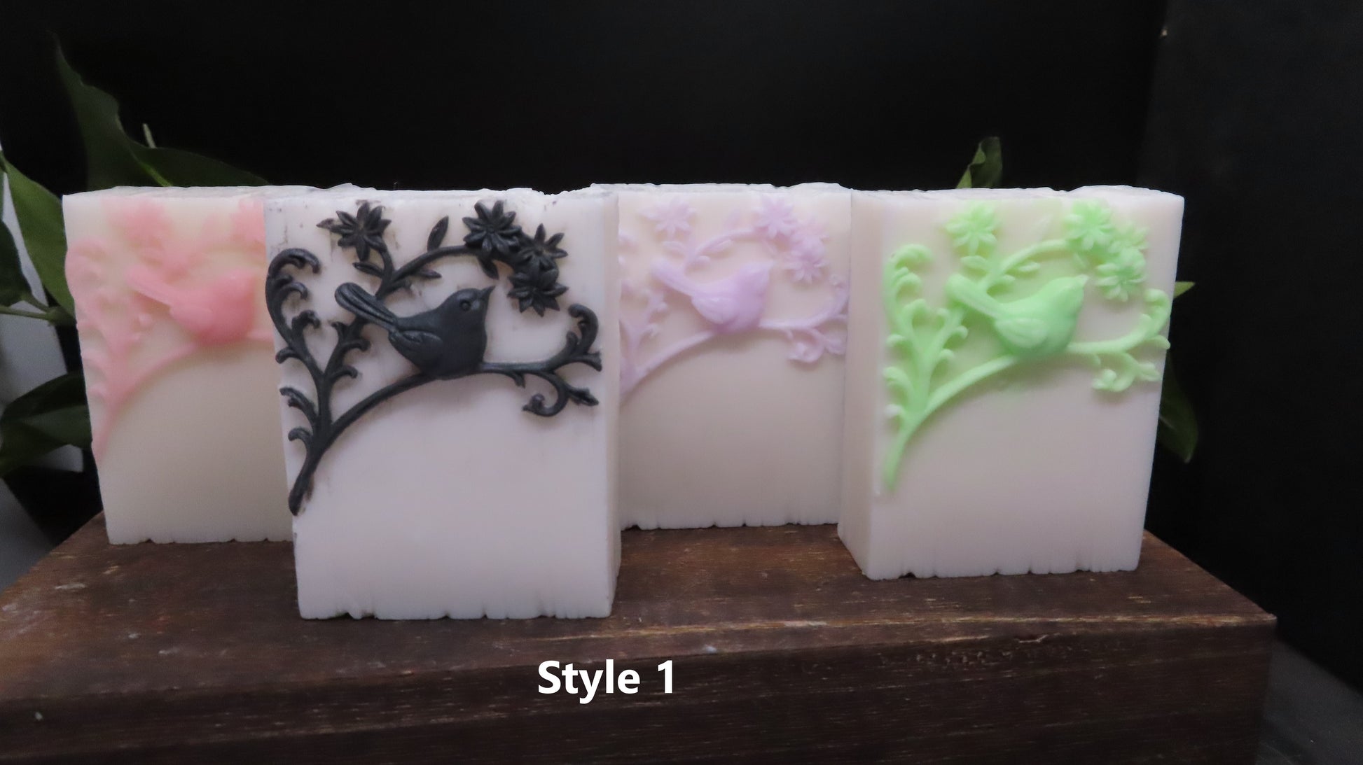 4 bars showing different color options:  Pink, black, purple and green details on white bars handmade goat milk soaps