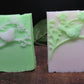 2 handmade bird soap bars:  1 white details on green bar the other green details on a white bar. 
